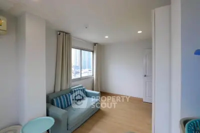 Bright living room with modern sofa and large window offering city views.