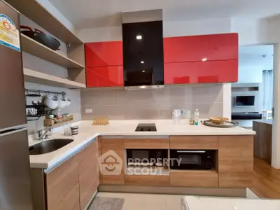 Modern kitchen with red cabinets and sleek appliances in stylish apartment
