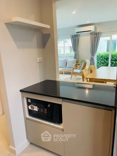 Modern open-layout kitchen with sleek cabinetry and view into stylish living room