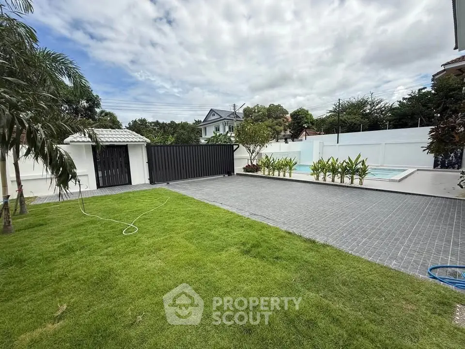 Spacious backyard with lush lawn and modern pool, perfect for outdoor relaxation and entertainment.