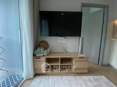 Modern living room with wall-mounted TV and stylish wooden cabinet, featuring a cozy ambiance and elegant decor.