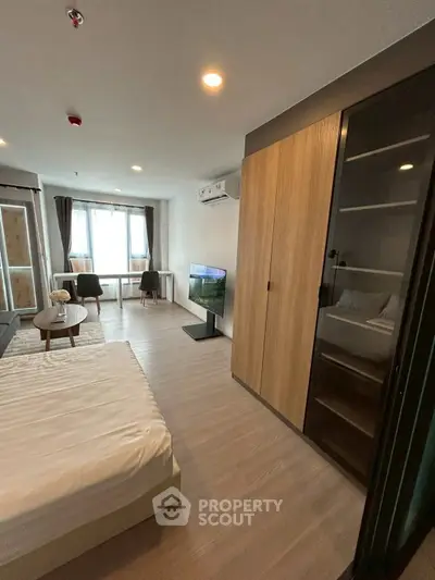 Modern bedroom with sleek furnishings and natural light, featuring a cozy workspace and stylish wardrobe.