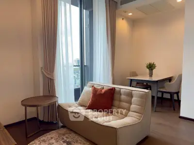 Modern living room with cozy seating and dining area, featuring large windows and elegant decor.