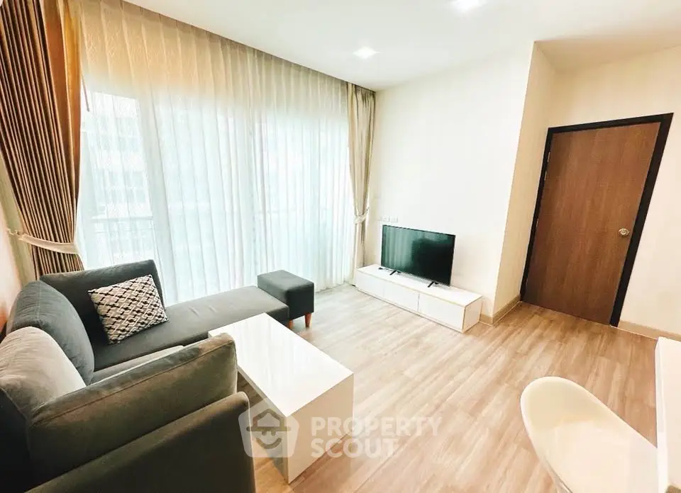 Modern living room with sleek furniture and natural light, perfect for relaxation and entertainment.