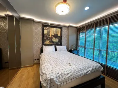 Luxurious bedroom with elegant decor and large windows offering serene views.