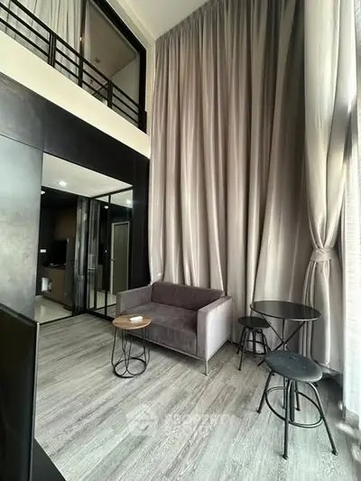 Modern loft-style living room with high ceilings and elegant drapes