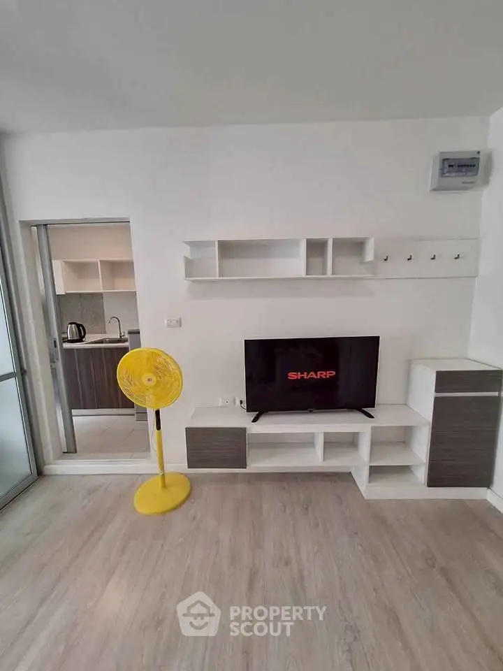Modern living room with sleek TV unit and open kitchen view