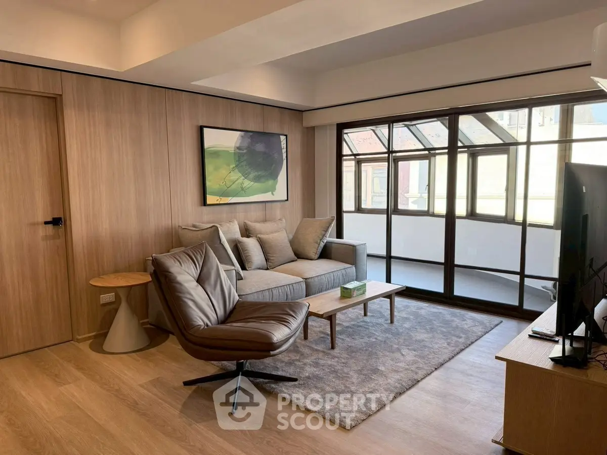 Modern living room with stylish furniture and large windows for natural light.