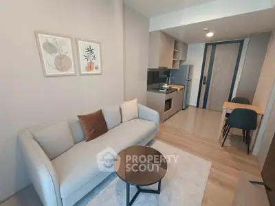 Modern living room with cozy sofa and stylish kitchen in open layout apartment.