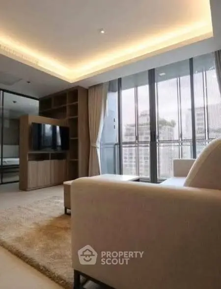 Modern living room with large windows and cozy seating area