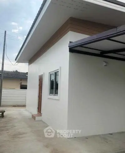 Modern minimalist exterior of a single-story home with clean lines and a covered carport.