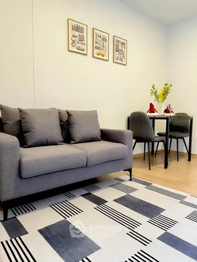 Modern living room with stylish gray sofa and chic dining area