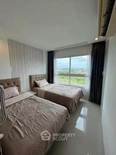Spacious bedroom with twin beds and scenic window view in modern apartment