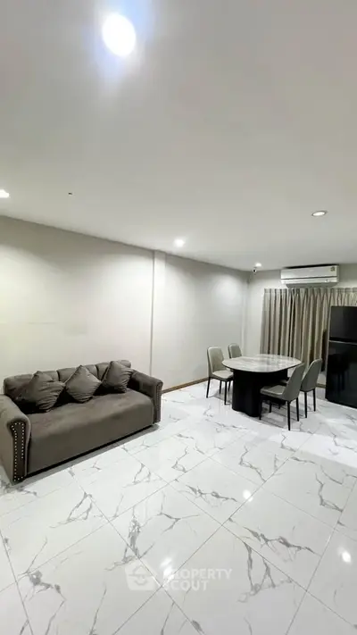 Modern living room with elegant marble flooring and cozy dining area