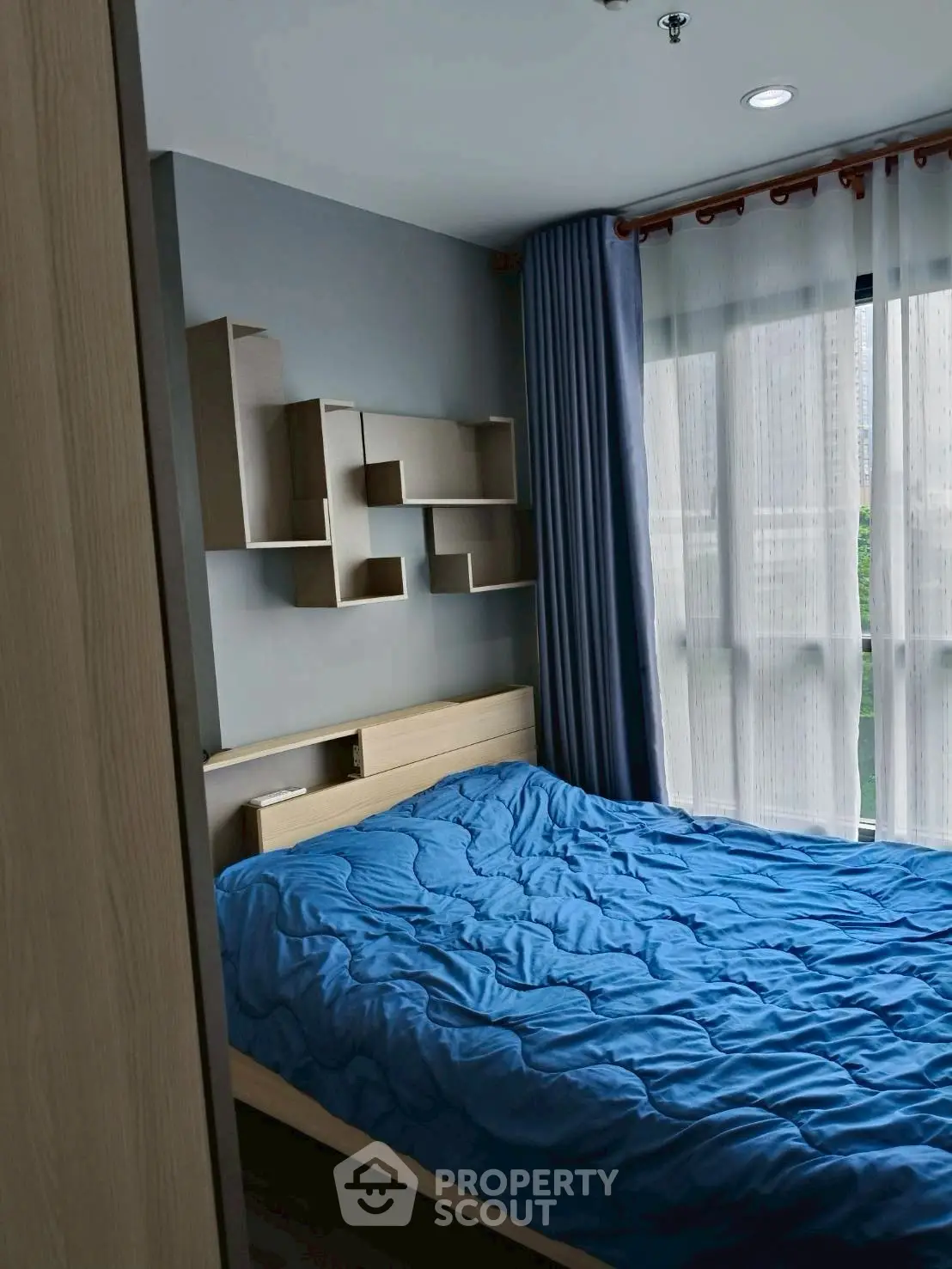 Cozy bedroom with modern decor and large window for natural light.