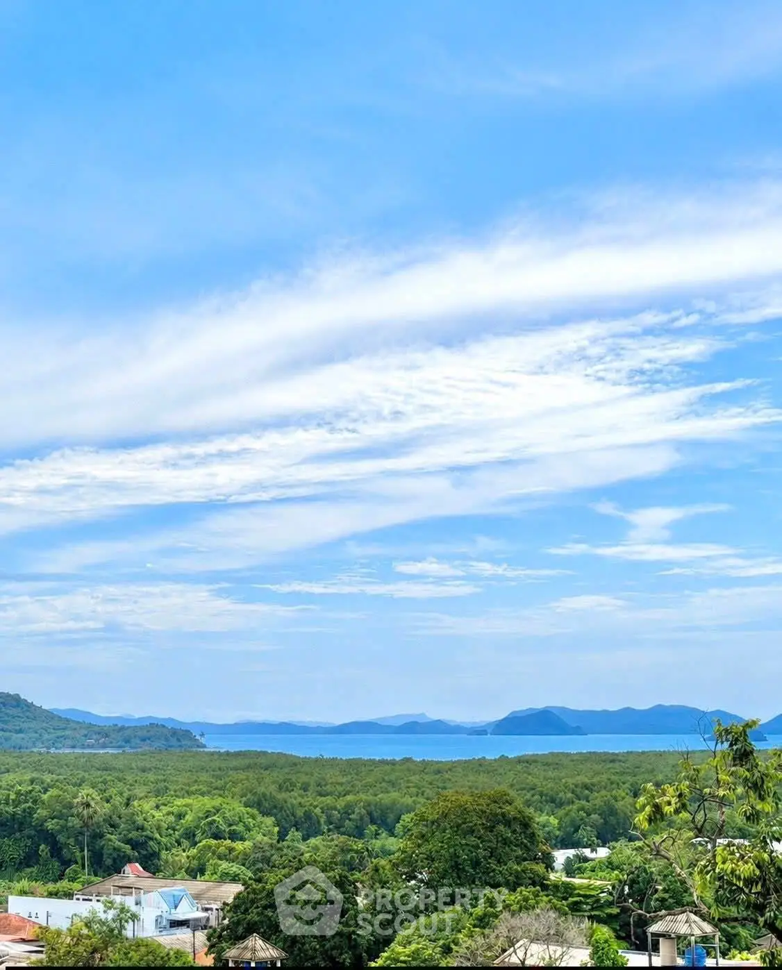 Stunning ocean view from a serene residential area with lush greenery and clear blue skies.