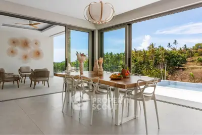 Luxurious open-plan dining area with stunning tropical views and modern decor.