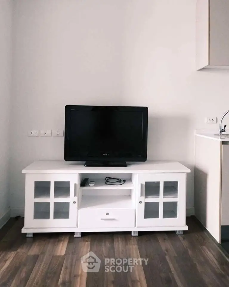 Modern living room with sleek TV stand and flat-screen TV, showcasing stylish interior design.
