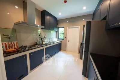 Modern kitchen with sleek blue cabinets and stainless steel appliances