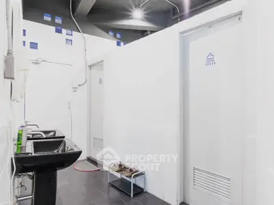 Modern bathroom with sleek black sink and shower stalls