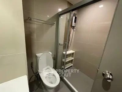 Modern bathroom with glass shower enclosure and sleek fixtures.