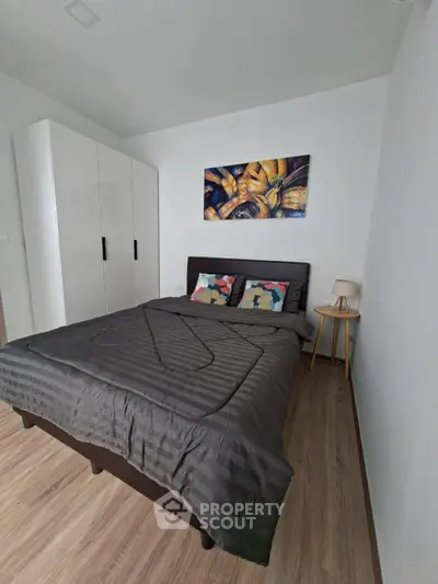 Modern bedroom with stylish decor and cozy ambiance, featuring a comfortable bed and elegant artwork.