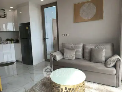 Modern living room with elegant decor and open kitchen layout, featuring a cozy sofa and stylish coffee table.