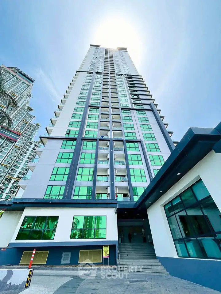 Stunning modern high-rise building with sleek design and vibrant green windows.