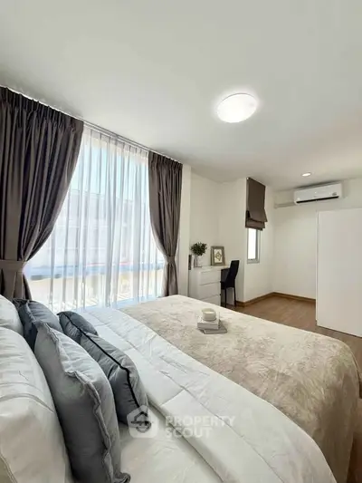 Bright and cozy bedroom with large window and modern decor