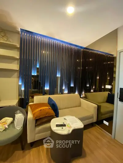 Modern living room with stylish lighting and cozy seating in a contemporary apartment.