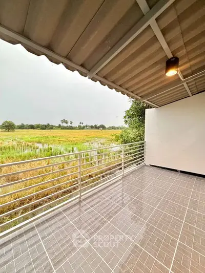 Spacious balcony with scenic countryside view, perfect for relaxation and enjoying nature.