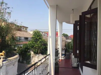 Spacious balcony with scenic view of surrounding neighborhood and lush greenery.