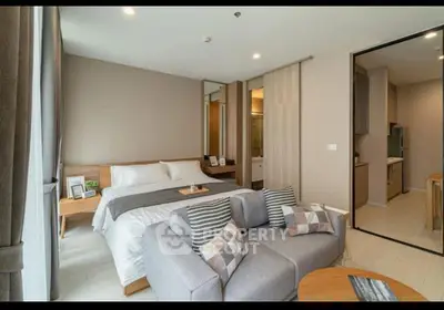 Modern bedroom with cozy seating area and open kitchen layout