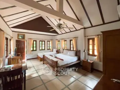 Spacious bedroom with wooden furniture and high ceiling, perfect for comfort and relaxation.