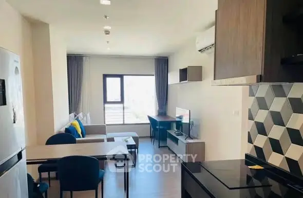 Modern living room with stylish decor and open kitchen layout in a bright apartment.