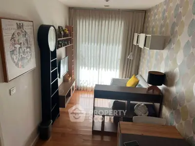 Charming living room with stylish decor, wooden flooring, and ample natural light from large window.