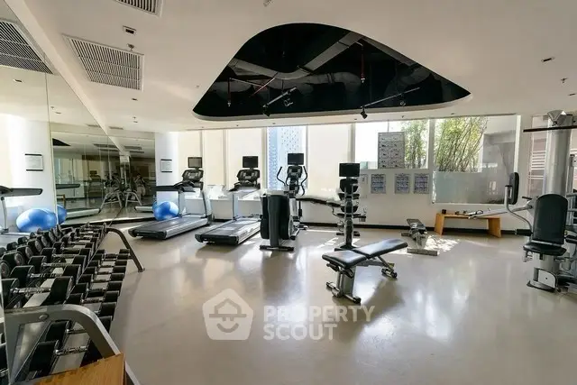 Spacious modern gym with state-of-the-art equipment and natural light.