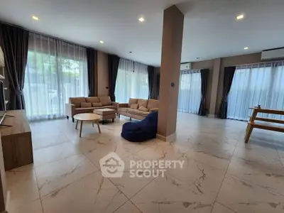 Spacious modern living room with large windows and elegant furnishings