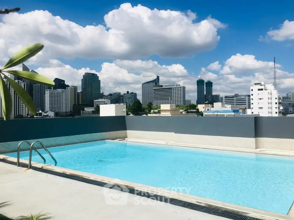 Stunning rooftop pool with city skyline views under a clear blue sky.