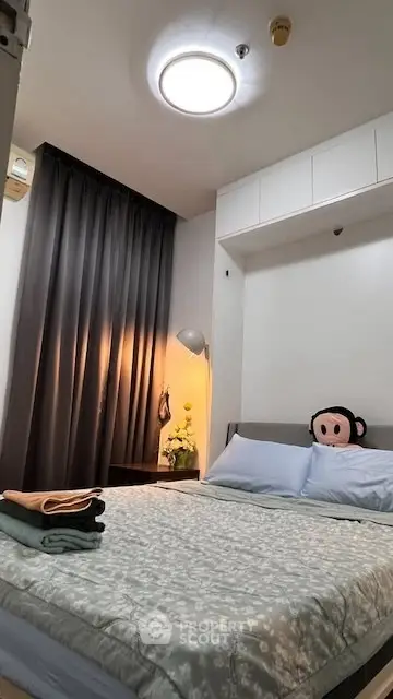 Cozy bedroom with modern decor and soft lighting, featuring a comfortable bed and stylish curtains.