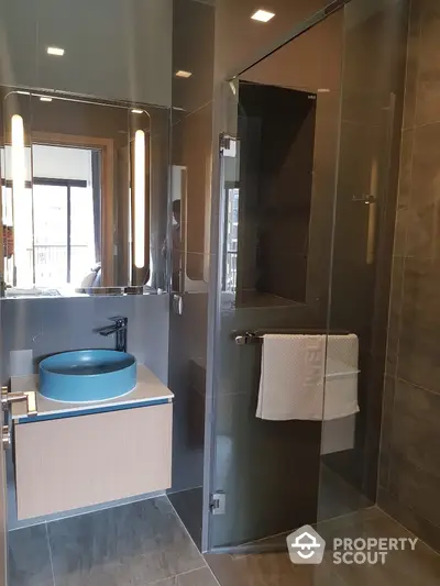 Modern bathroom with sleek glass shower and stylish blue sink