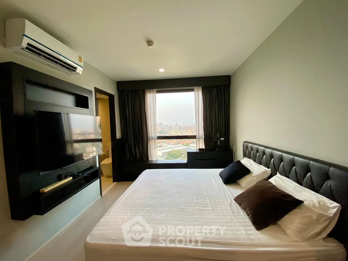 Modern bedroom with city view, featuring sleek design and large window for natural light.