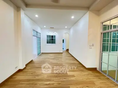 Spacious interior with wooden flooring and bright lighting, ideal for modern living.