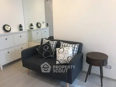 Modern living room with stylish sofa and decorative pillows, featuring minimalist decor and elegant furnishings.