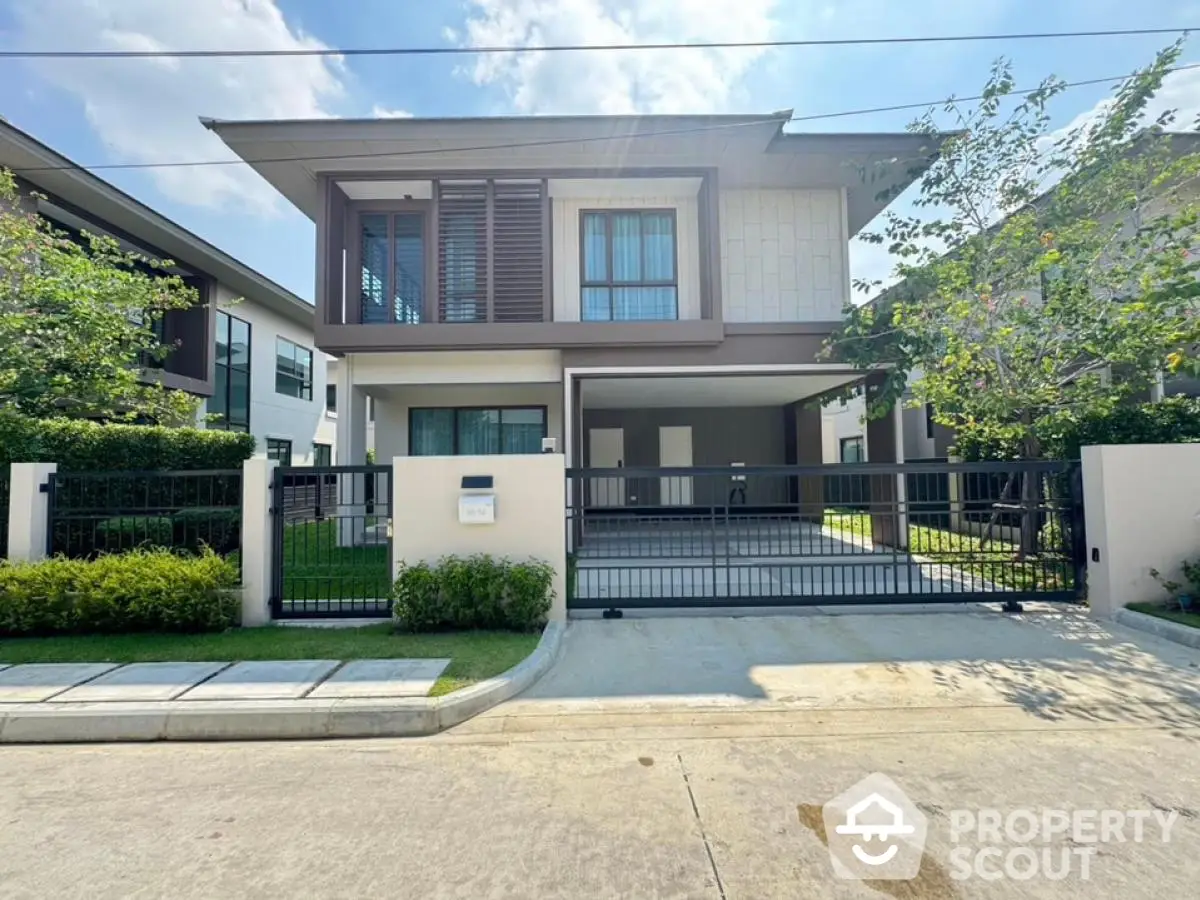 Modern two-story house with spacious driveway and lush greenery in a serene neighborhood.