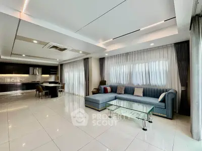 Spacious modern living room with elegant sofa and open kitchen layout