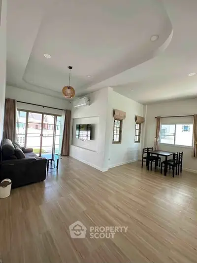 Spacious living room with modern decor and large windows for natural light