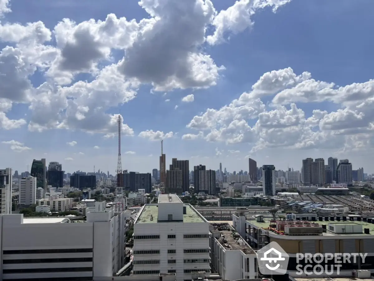 Stunning cityscape view from high-rise building showcasing urban skyline under a vibrant blue sky.