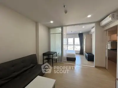 Modern open-plan living room with bedroom view and natural light