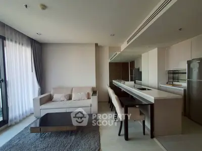 Modern open-plan living room with sleek kitchen and cozy seating area